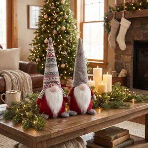 Set of two Christmas gnomes with knit hats on a wooden table with festive background