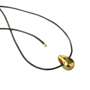 Minimalist gold teardrop pendant on black cord necklace with high-polish finish