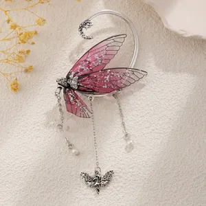 Zoom sur un tour d'oreille aile de papillon rose avec perles et chaînes