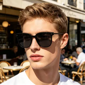 Outdoor shot of a man wearing black large-frame polarized sunglasses in a cafe setting