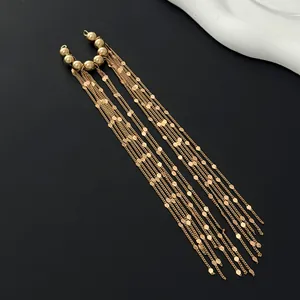 Detailed macro shot of elegant gold tassel ear cuff with multiple long chain drops