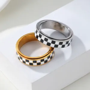 Pair of gold and silver 304 stainless steel checkerboard spinner rings on white block