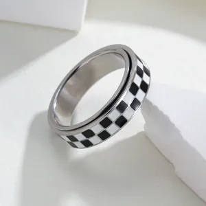 Close-up of rotatable stainless steel ring with black and white checkerboard pattern