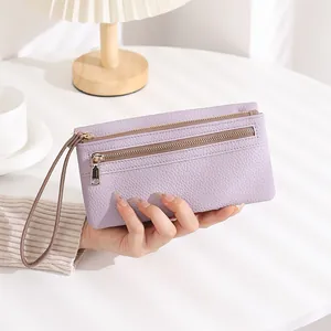 Detail of lavender litchi leather long wallet with double zippers and wrist strap