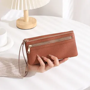 Brown leather textured long wallet featuring double zippers and a wrist strap details