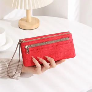 Detailed texture of red pebbled leather long wallet featuring a front zipper and wristlet