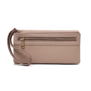 Detail of beige litchi grain leather clutch wallet with gold zippers and wristlet strap