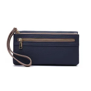 Detail of navy blue pebble leather long wallet featuring double gold zippers and wristlet