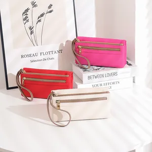Three leather wristlet wallets in red, white and rose colors with gold zipper details