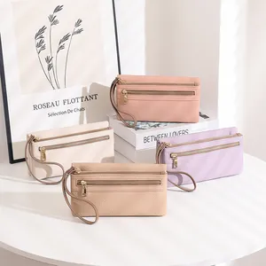 Detailed view of multi-compartment long wallets in pink and beige lychee pattern leather
