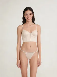 Détail d'un soutien-gorge corset en satin beige avec dentelle et agrafes devant