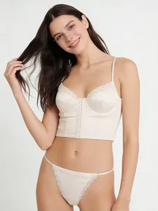 Detail of white satin lace bralette set with front buttons and delicate straps