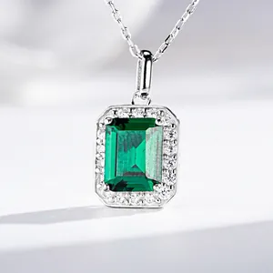 Macro shot of an emerald-cut green gemstone necklace with a sparkling diamond halo
