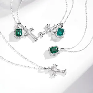 Macro detail of silver emerald cut green gemstone and cross pendant with micro diamonds
