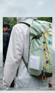 Compact white mesh pouch for EVA raincoat tucked into a green backpack side pocket