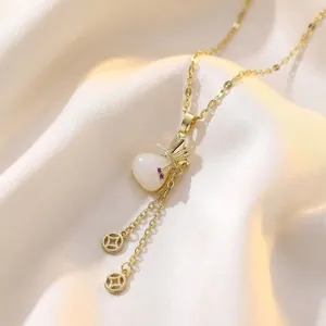 Vintage gold necklace featuring a white teardrop stone and fan-shaped charm on satin