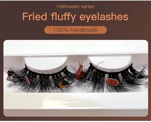 Détail de faux cils d'Halloween faits main avec breloques citrouille et chauve-souris