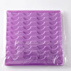 Purple wavy plastic eyelash display tray in transparent protective plastic packaging
