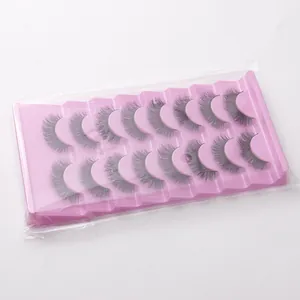 Gros plan de 10 paires de faux cils épais et recourbés dans un plateau en plastique rose