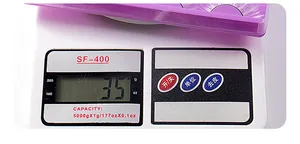 Macro view of white false eyelashes in purple packaging weighing 35g on a digital scale