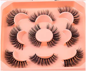 Detailed close-up of 7 pairs of thick, multilayered faux mink eyelashes in a pink tray