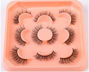 Close-up of 7 pairs of thick curly black faux mink eyelashes on orange display tray