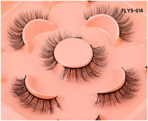 Macro view of five pairs of 3D layered faux mink eyelashes on a peach tray