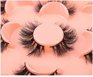 Macro shot of 5 pairs of thick multi-layered faux mink eyelashes in a pink round tray