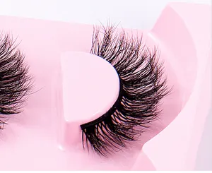Detailansicht der dichten mehrlagigen falschen Wimpern auf einem rosa Tablett