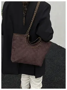 Détail du sac cabas en daim marron matelassé avec bandoulière en chaîne dorée