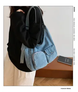 Détail du sac hobo en jean bleu clair avec poches frontales et texture denim délavé