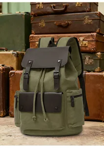 Detail of army green canvas backpack with leather straps against retro suitcases