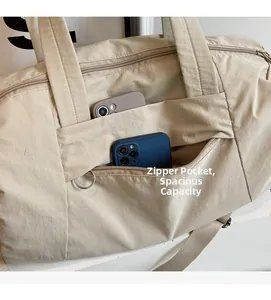Dettaglio della borsa da viaggio in nylon beige con tasca a zip e scomparti laterali aperti
