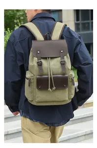 Rear view of man wearing vintage olive canvas backpack with leather straps and large capacity