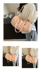 Dettaglio borsa da viaggio in nylon rosa con tracolla regolabile e cerniere metalliche