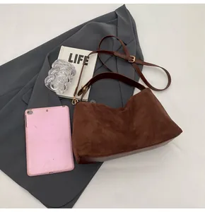 Détail du sac cabas vintage en daim avec bandoulière réglable et base en cuir