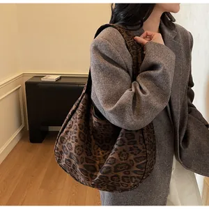Detalle del bolso tote grande con estampado de leopardo llevado por una modelo en otoño