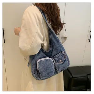 Gros plan détaillé du sac cabas en jean bleu avec poches fonctionnelles et texture délavée