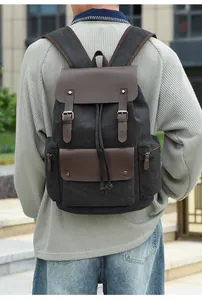 Close-up of retro black canvas backpack with brown leather buckles and drawstring closure