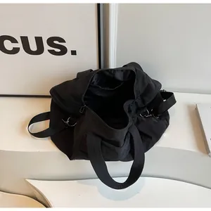 Dettaglio della grande borsa da viaggio nera in nylon impermeabile con ganci in argento