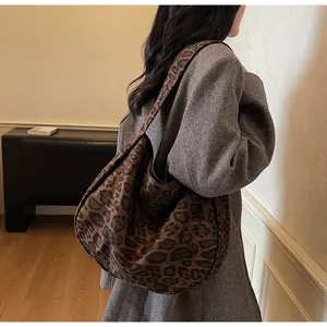 Detalle del bolso hobo grande con estampado de leopardo y correa ancha en una modelo