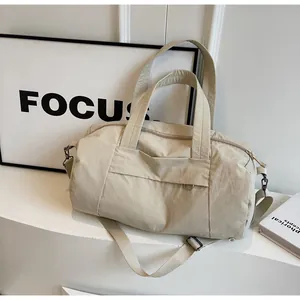 Dettaglio della borsa da viaggio in nylon beige impermeabile con manici e tracolla