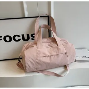 Borsa da viaggio rosa chiaro in nylon impermeabile in un ambiente di vita quotidiana