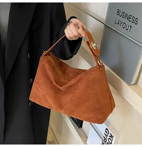 Détail du sac Boston en daim caramel montrant la texture douce et le fermoir doré