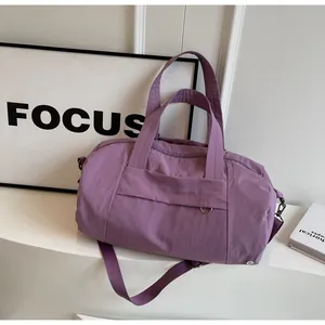 Dettaglio borsa da viaggio viola impermeabile con manici e anello metallico a D