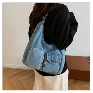 Détail du sac hobo en jean avec poches de style cargo et boutons métalliques argentés