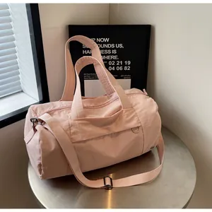 Dettaglio borsa da viaggio rosa in nylon impermeabile con tracolla e fibbie in metallo