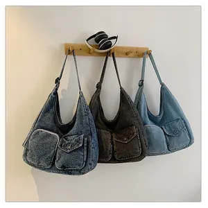 Détail de trois sacs hobo en denim disponibles en bleu foncé, gris noir et bleu clair