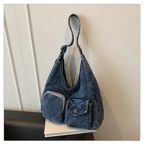 Vue détaillée du sac hobo en denim bleu rétro avec poches cargo et boutons métalliques