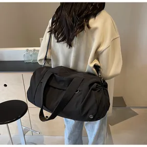 Vista modella di una grande borsa da viaggio in nylon nero impermeabile con tracolla